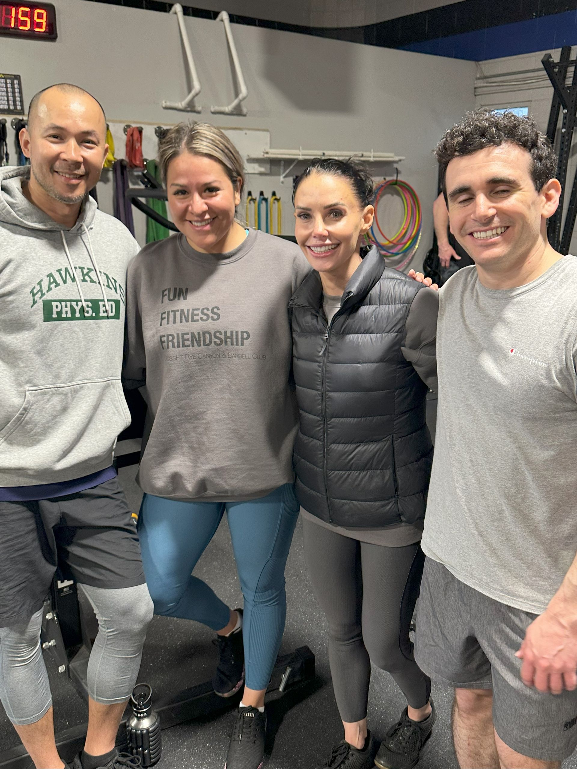 A group of people are posing for a picture in a gym.