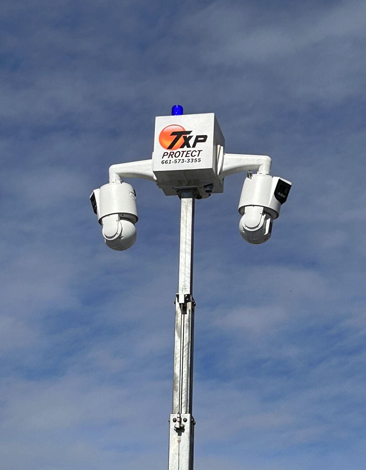 A white pole with two cameras on it that says TXP Protect on it.