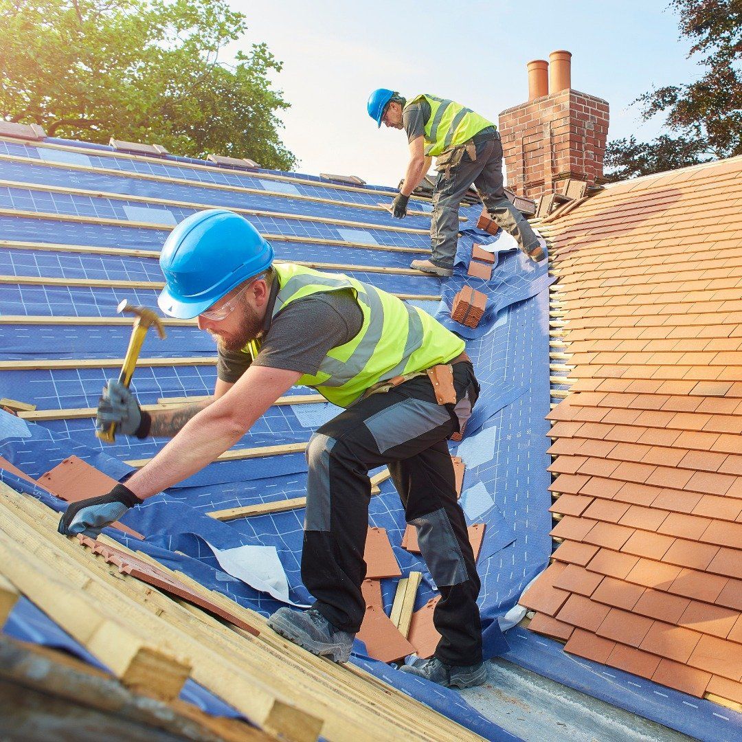 Two men are working on the roof of a house.
