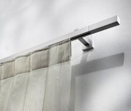 Bastone per tende bianco con tenda bianca trasparente appeso a una parete bianca.