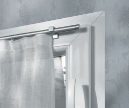 Tenda bianca appesa a un'asta di metallo all'interno di una cornice bianca della finestra. Parete grigia.