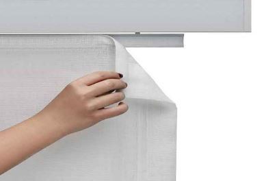 Mano che solleva l'angolo di una tenda bianca e trasparente.