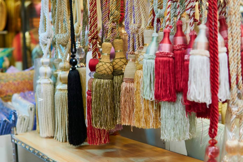 Varie nappe colorate appese in mostra.