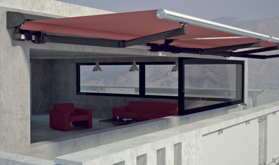 Tenda da sole rossa retrattile che si estende su un balcone moderno con spazio abitabile all'interno.