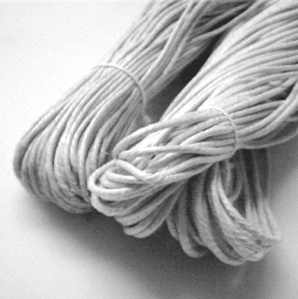 Fasci di cordino di cotone bianco legati con elastici.