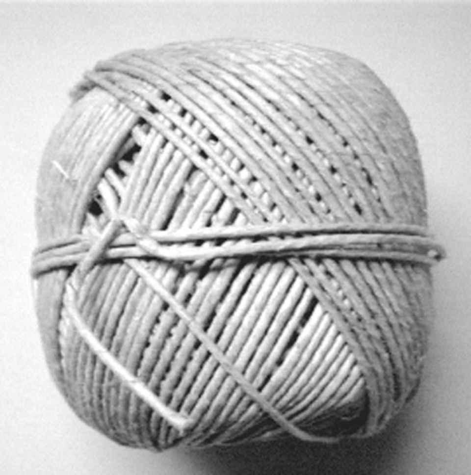 Gomitolo di spago avvolto in un motivo, di colore marrone chiaro.