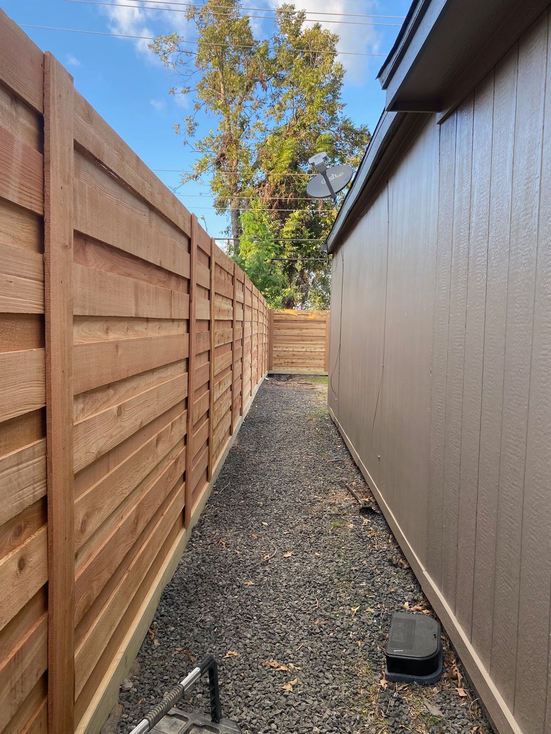 A wooden fence along the side of a house.