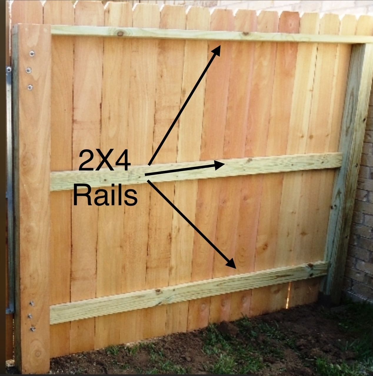 A wooden fence with 2x4 rails on it