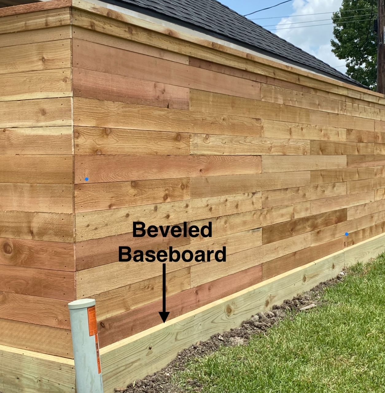 A wooden fence with a beveled baseboard attached to it