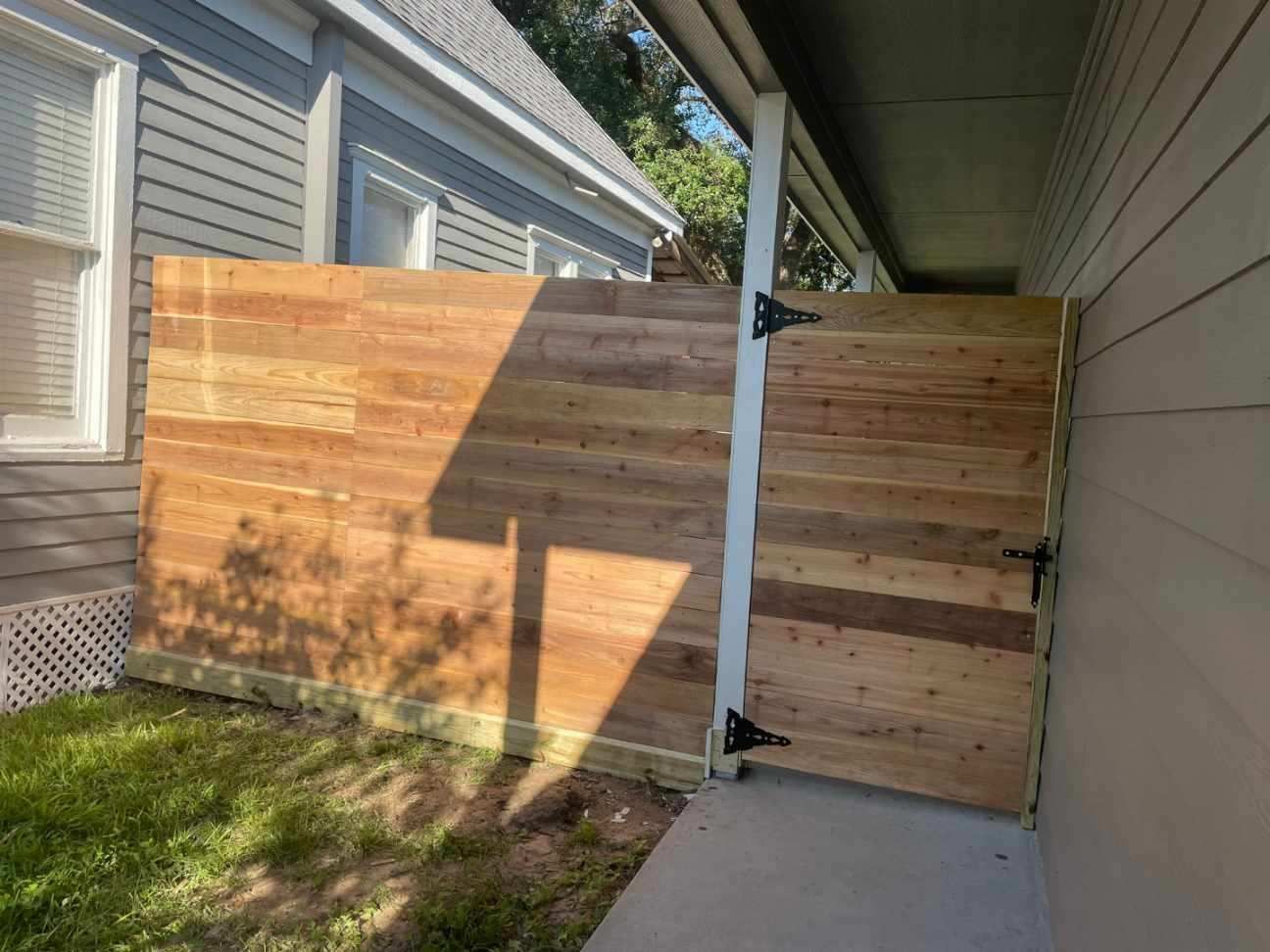 A wooden fence is sitting next to a house.