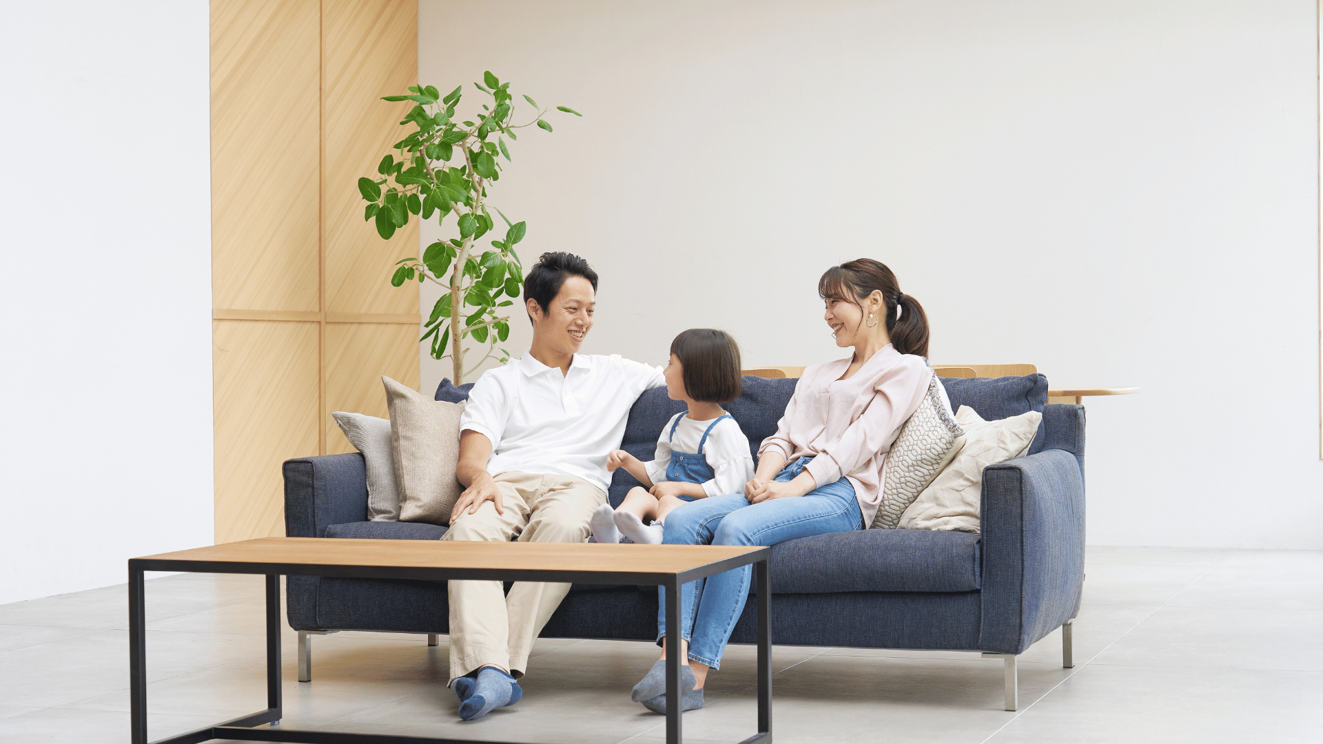 A family is sitting on a couch in a living room.