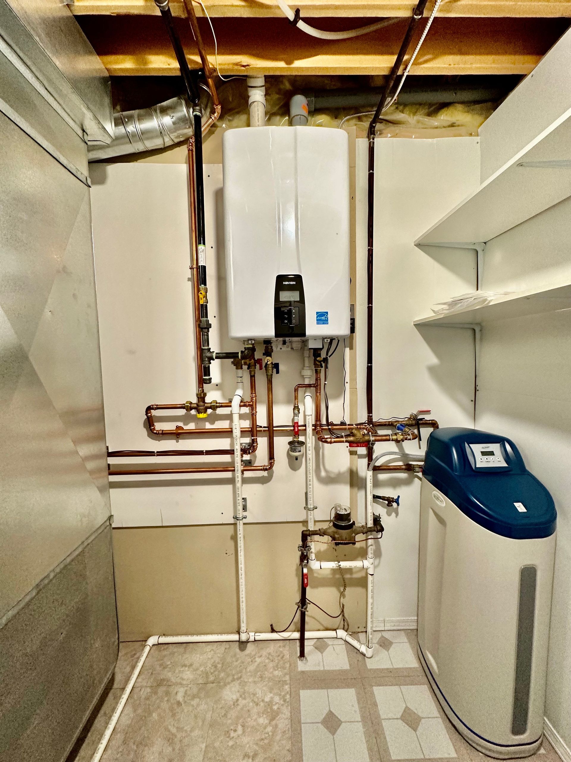 A room with a boiler and a water softener in it