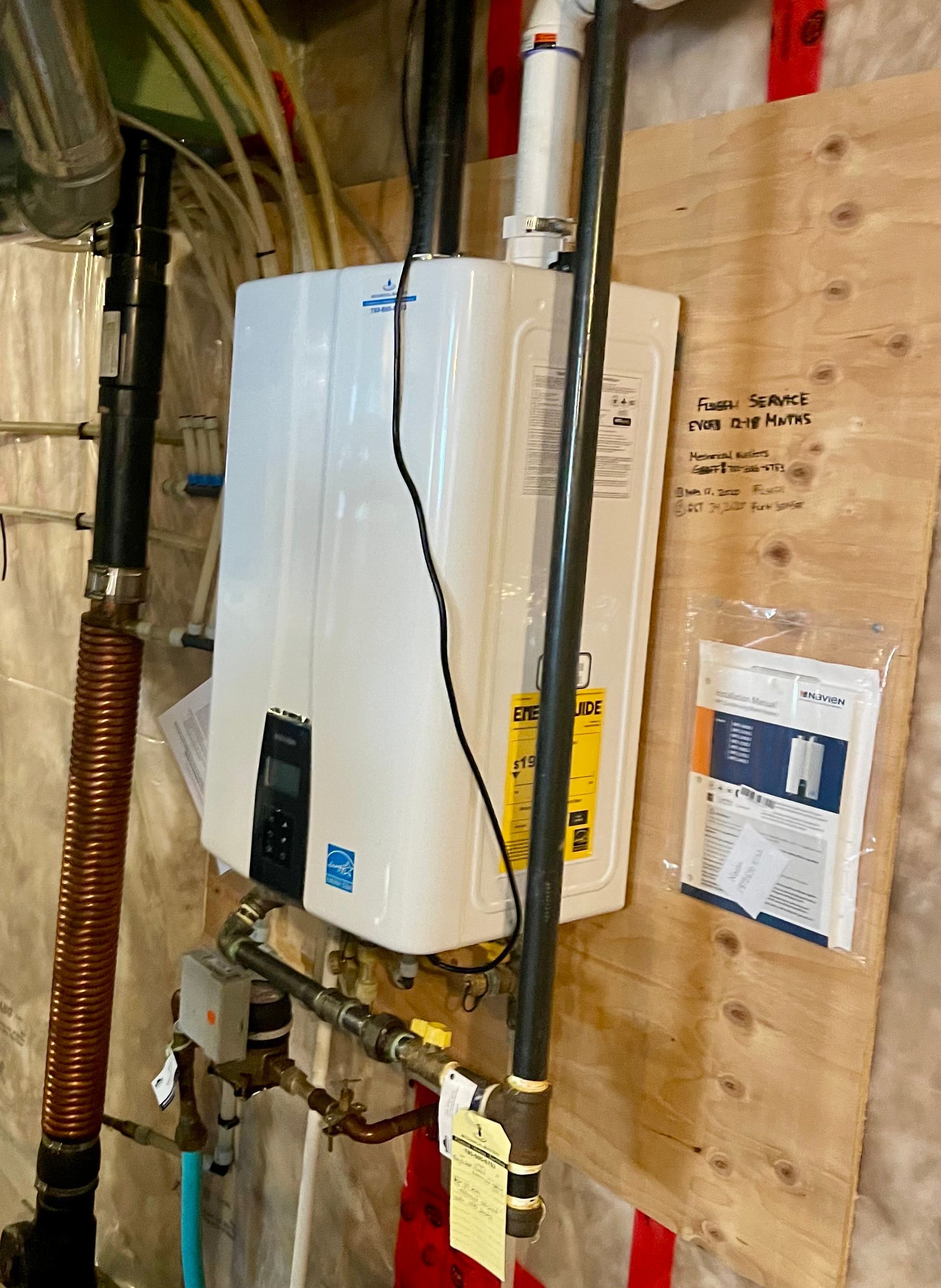 A water heater is hanging on a wall in a basement.