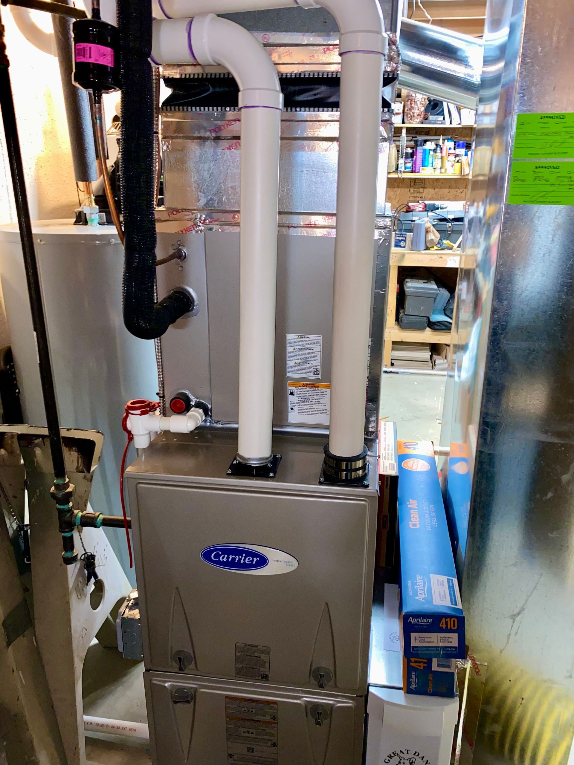 A stainless steel air conditioner is sitting in a basement.