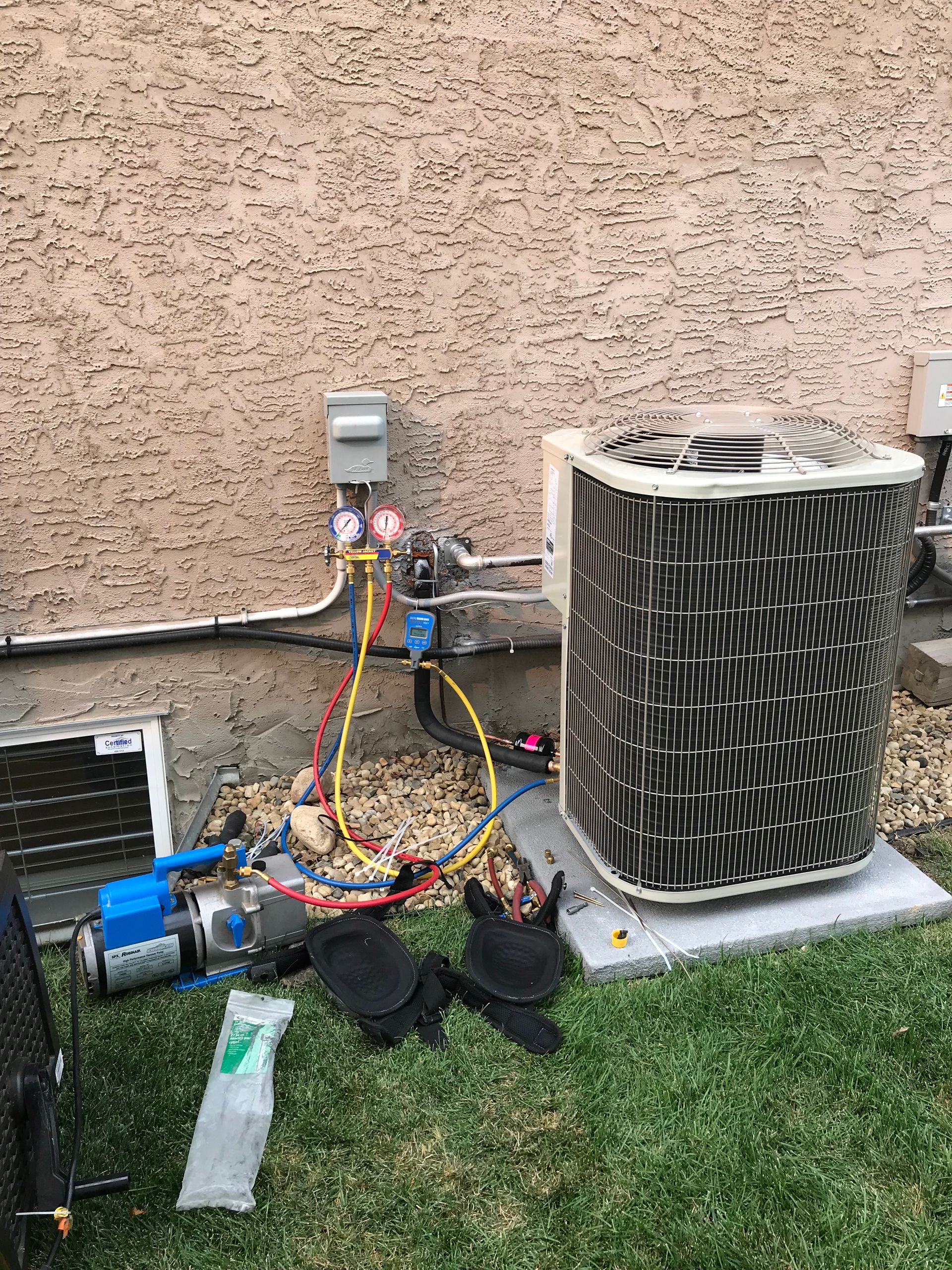 A couple of air conditioners are sitting on top of a lush green lawn.