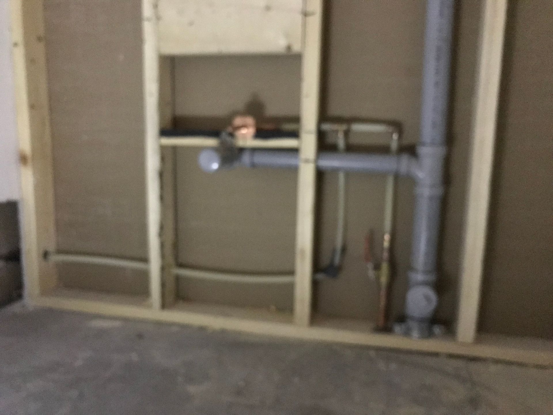 A room with a sink and pipes in it