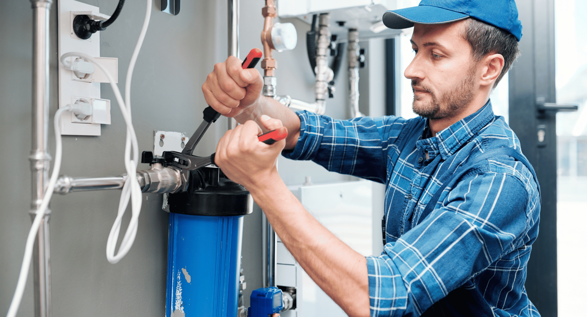 A man is fixing a pipe with a pair of pliers.