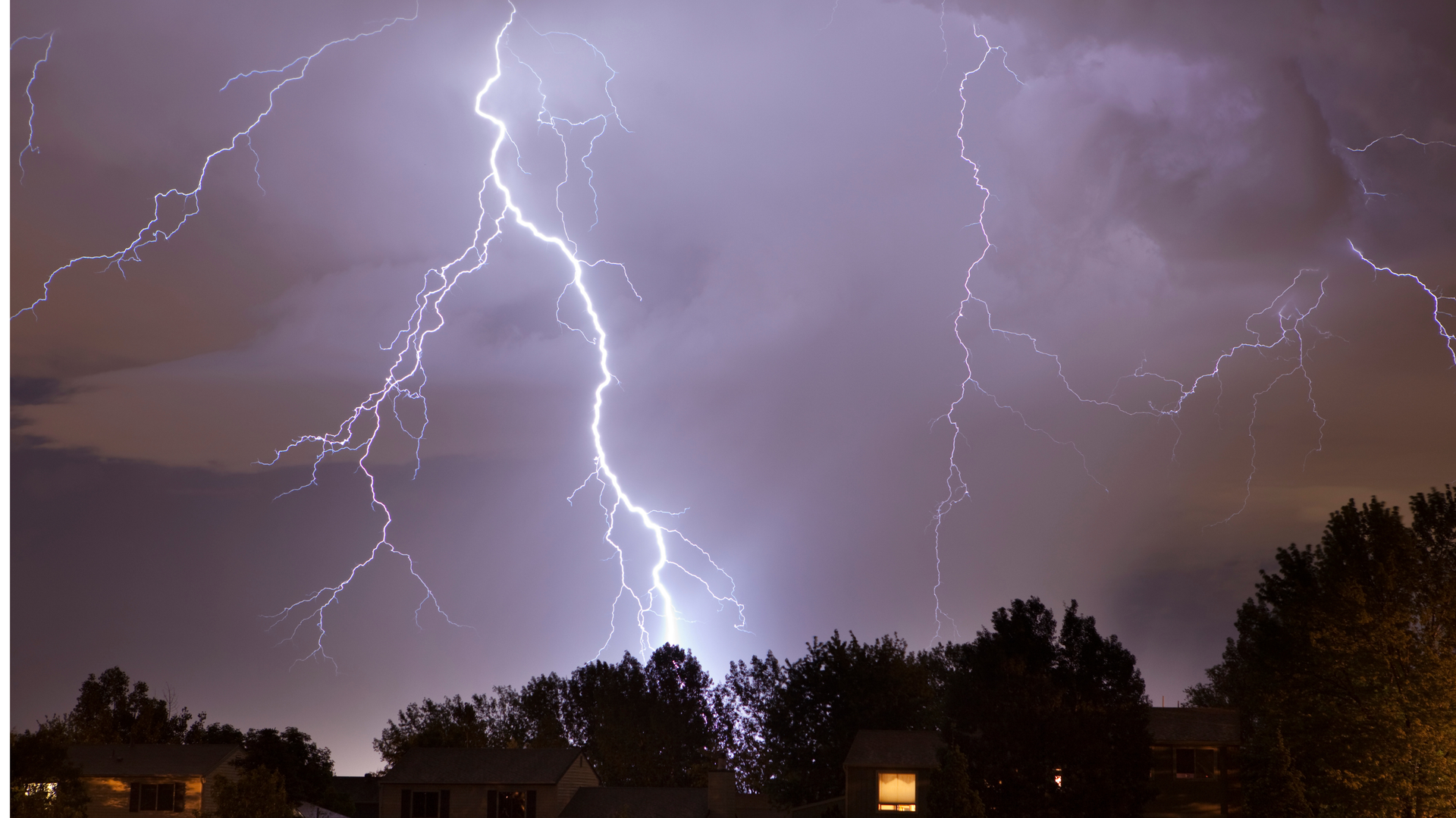 Lightning strike over houses at night