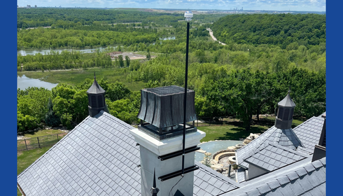 CMCE system mounted to the side of a chimney on a luxury home