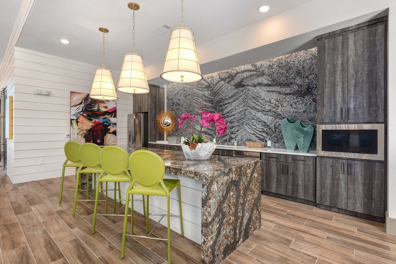 Modern kitchen with granite island, lime-green bar stools, and dark wood cabinets.
