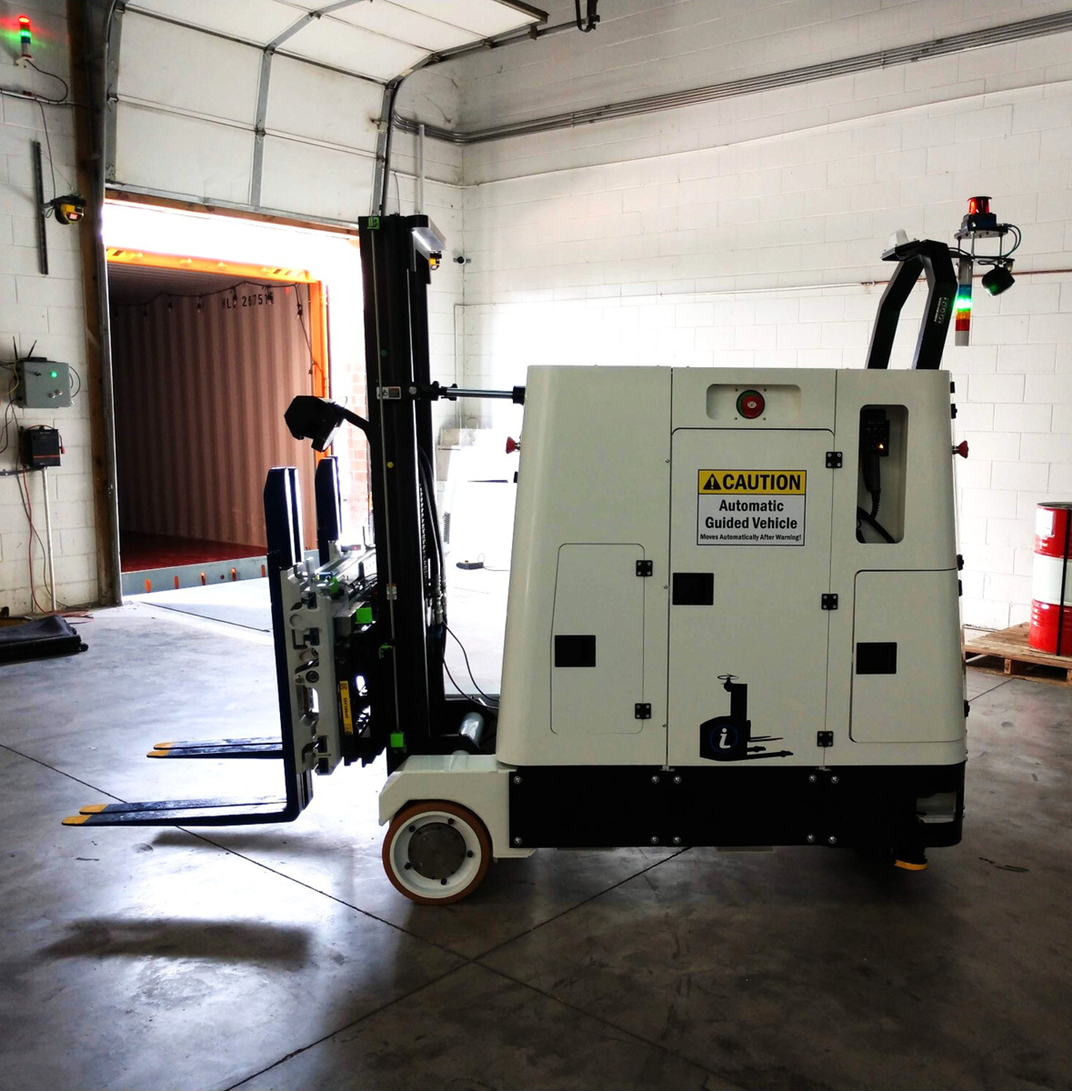 A white forklift with a caution sign on it