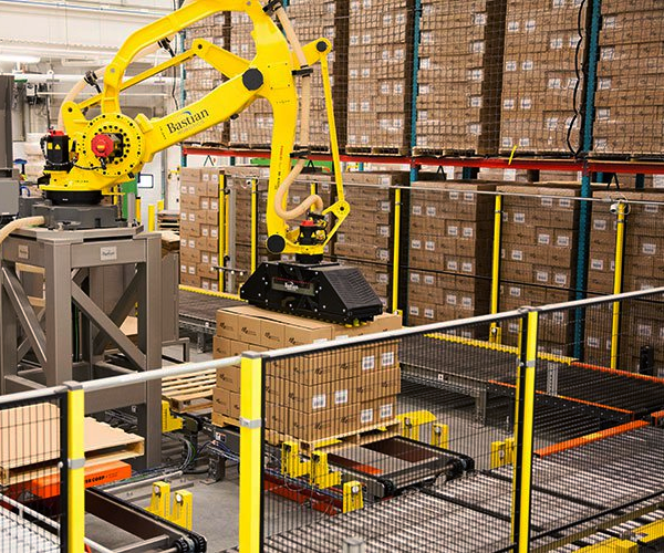 A yellow robot is moving boxes in a warehouse