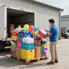Un hombre descarga coloridas cajas de juguetes y suministros de un camión de reparto sobre un palé.
