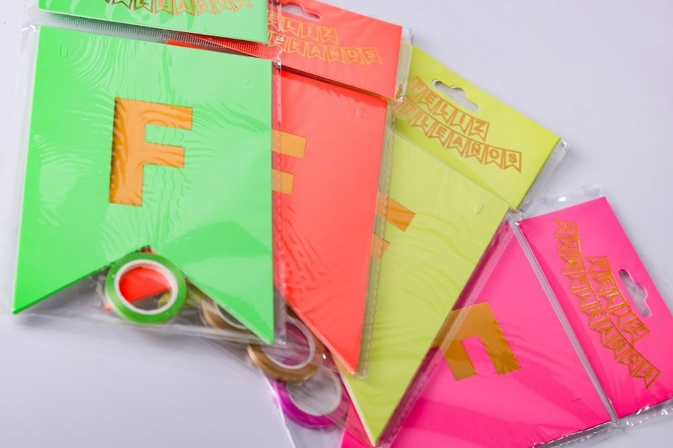 Tarjetas colgantes coloridas con el alfabeto y las letras grandes F, E y M sobre un fondo claro.