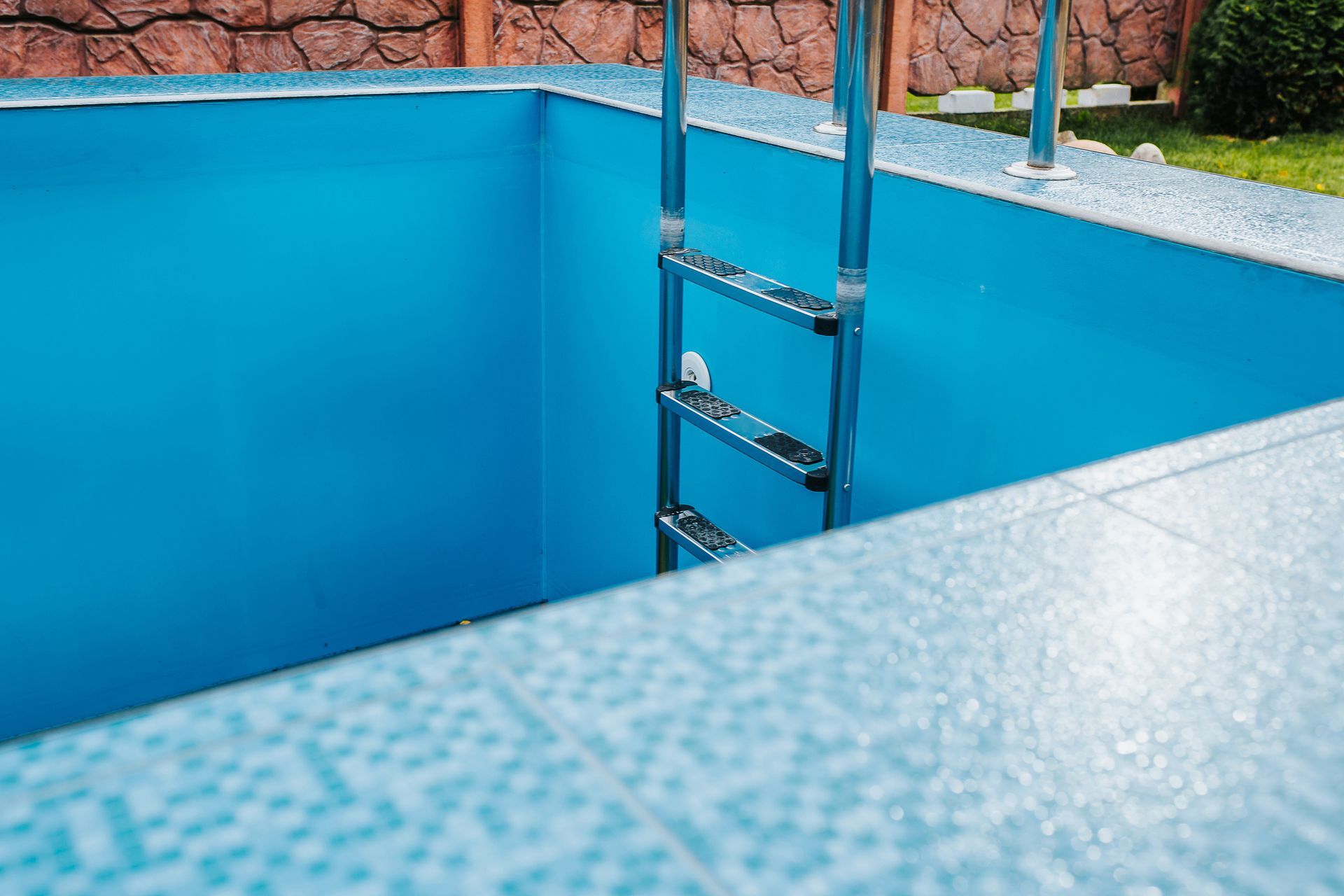 Blue mosaic tiles in pool cladding.