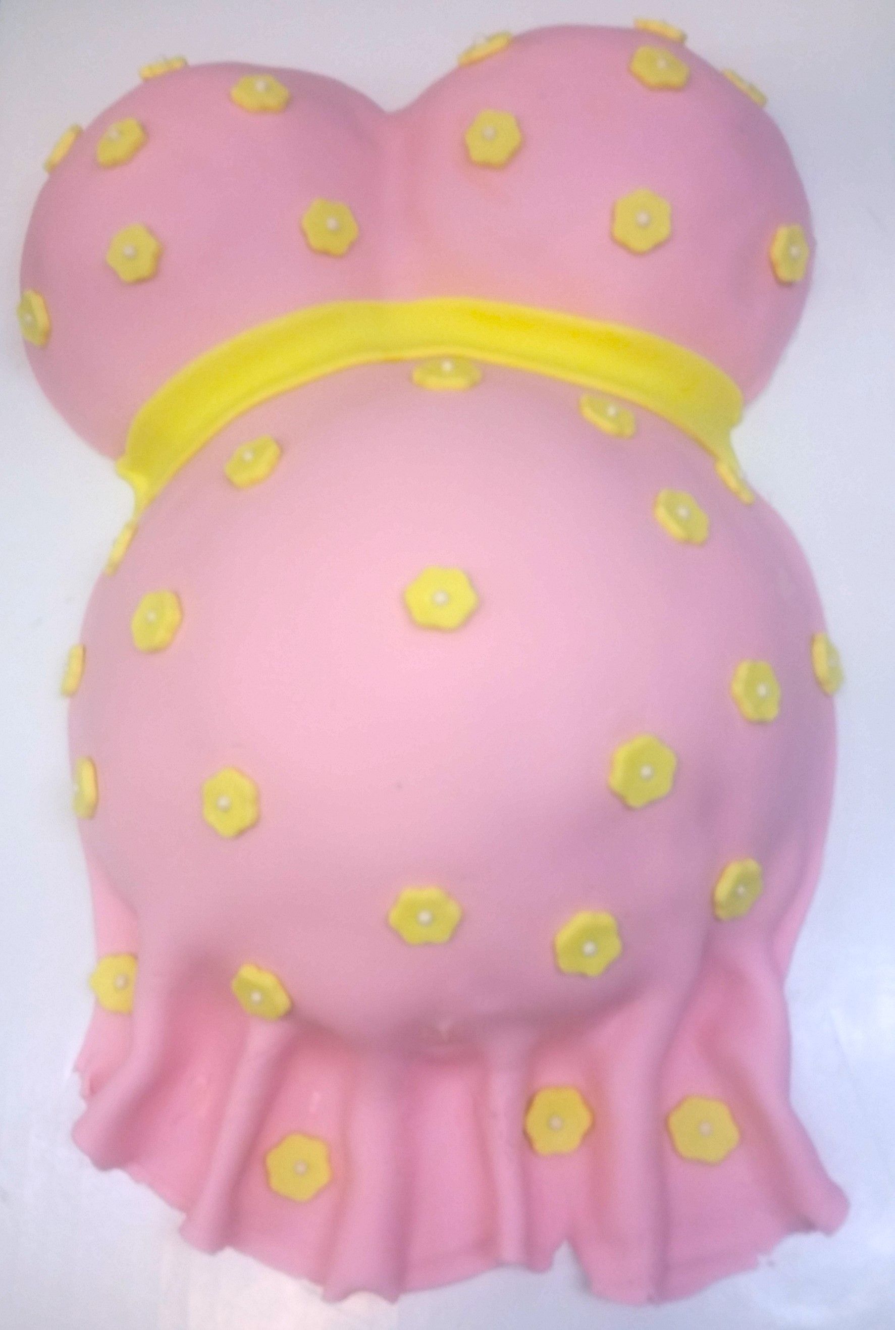 A pink cake that looks like a pregnant woman 's belly