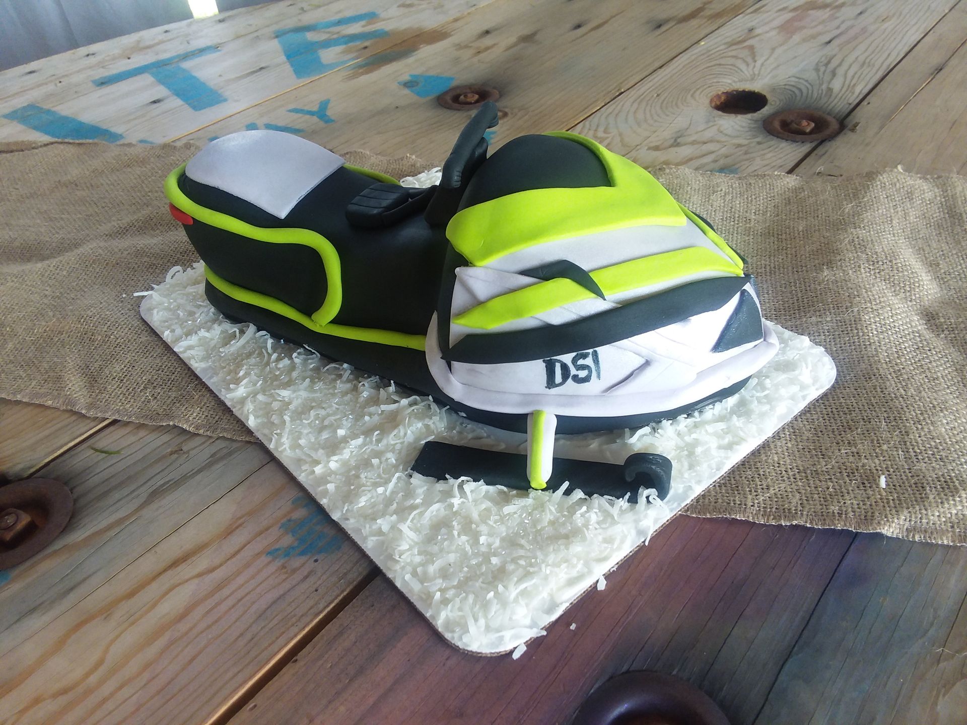 A cake that looks like a snowmobile with the word dsi on it