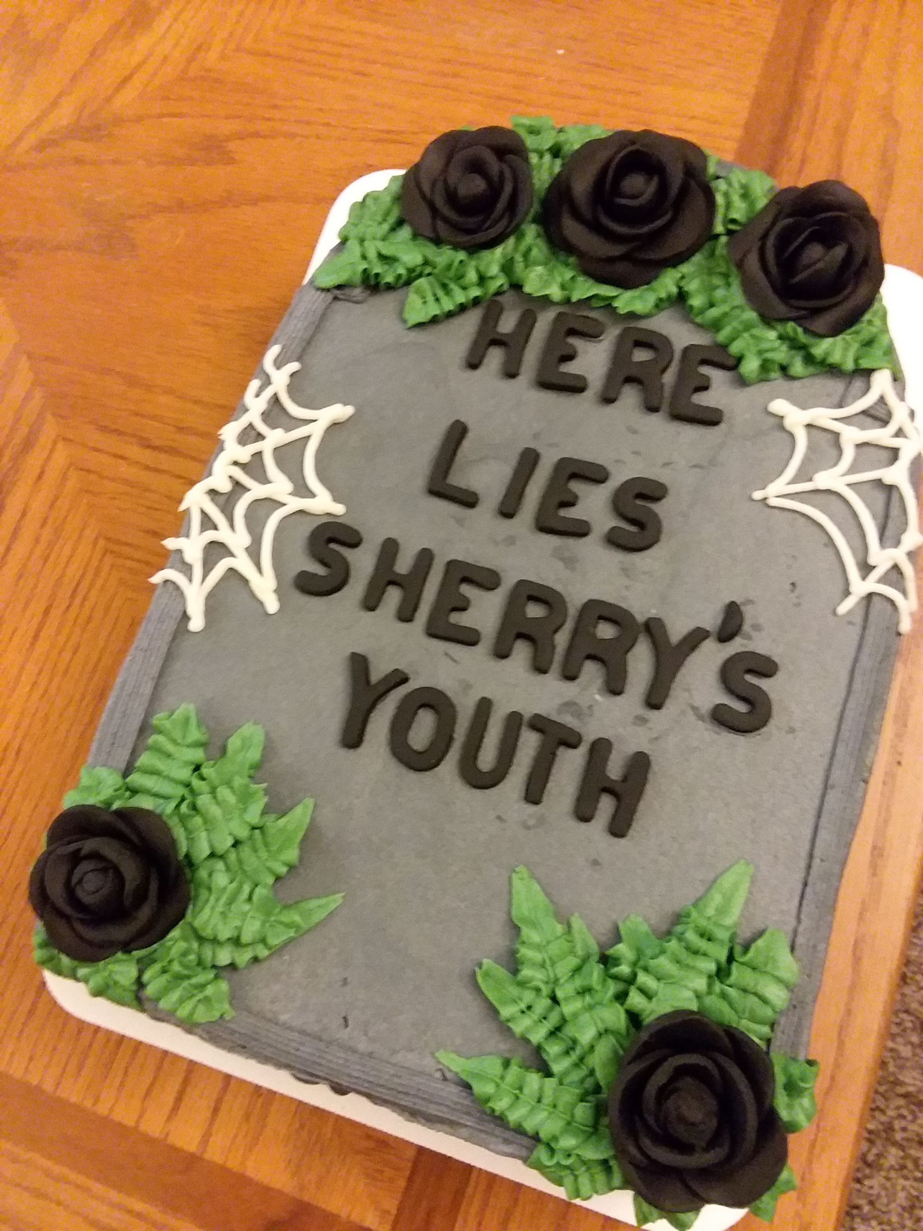 A cake that says here lies sherry 's youth