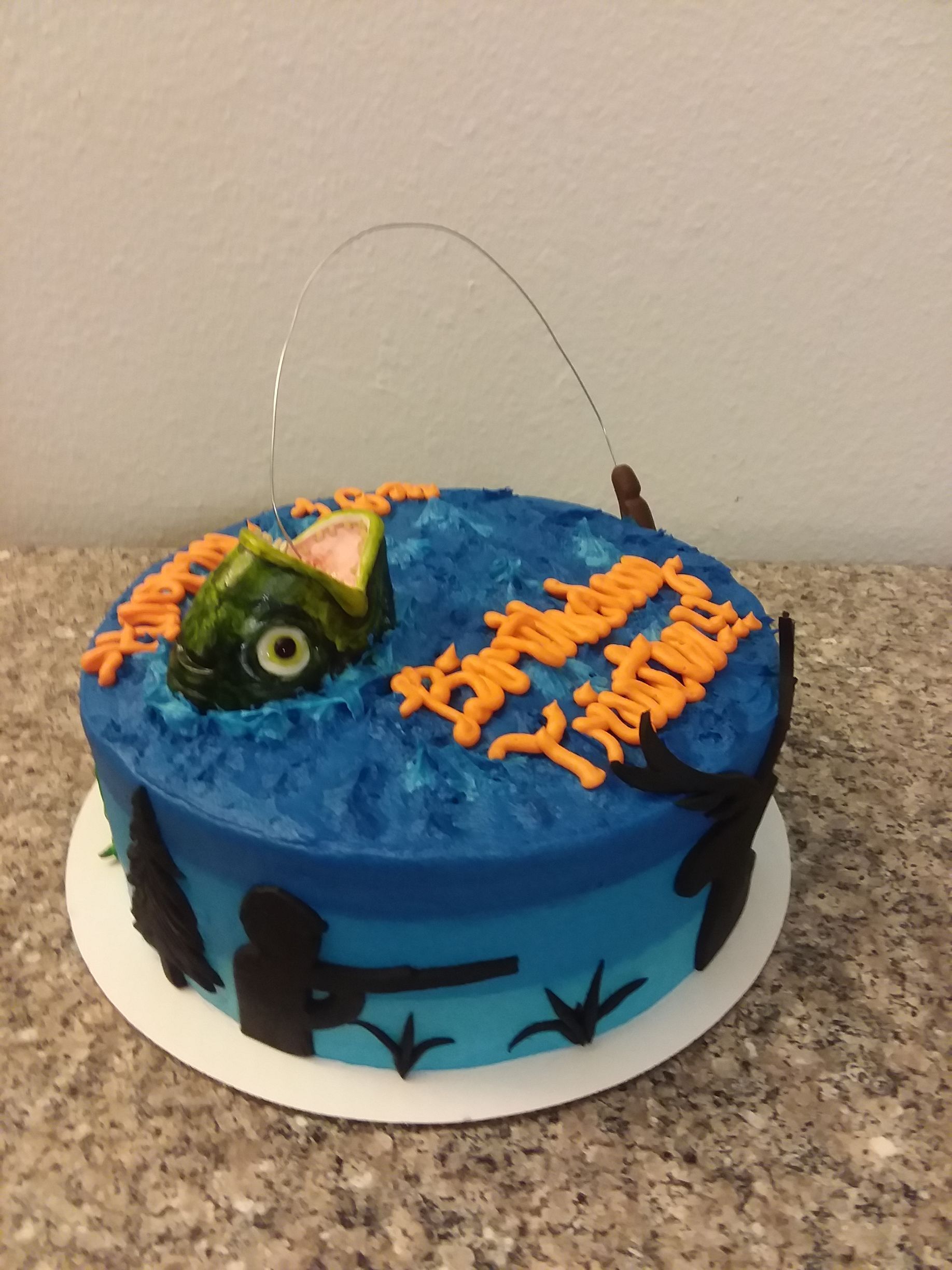 A cake with a fishing rod and a fish on it
