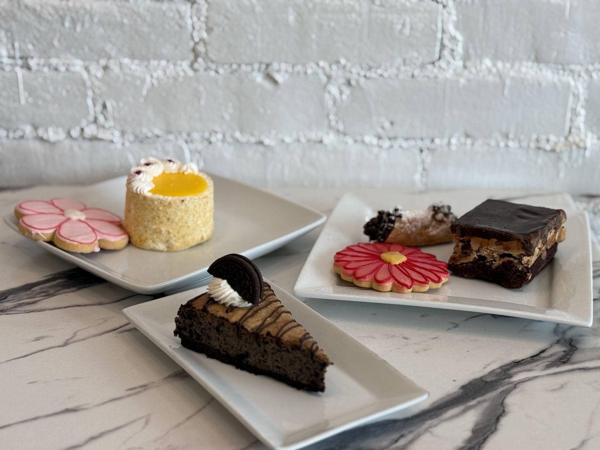A table topped with plates of desserts and cookies.