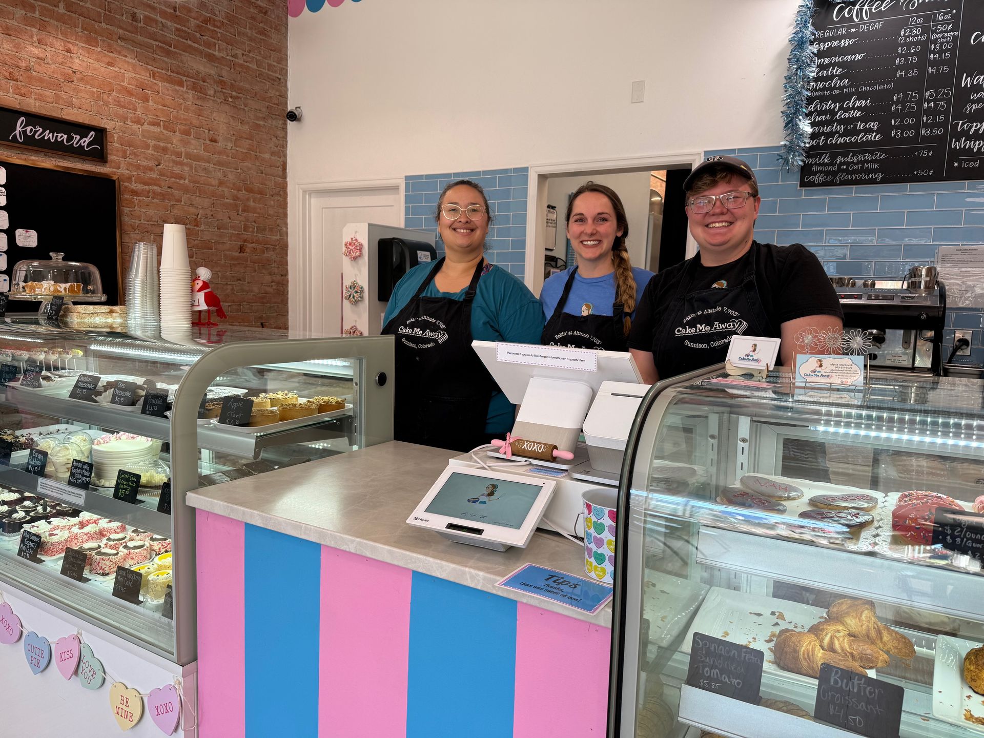 A group of people are standing behind a counter in a bakery.