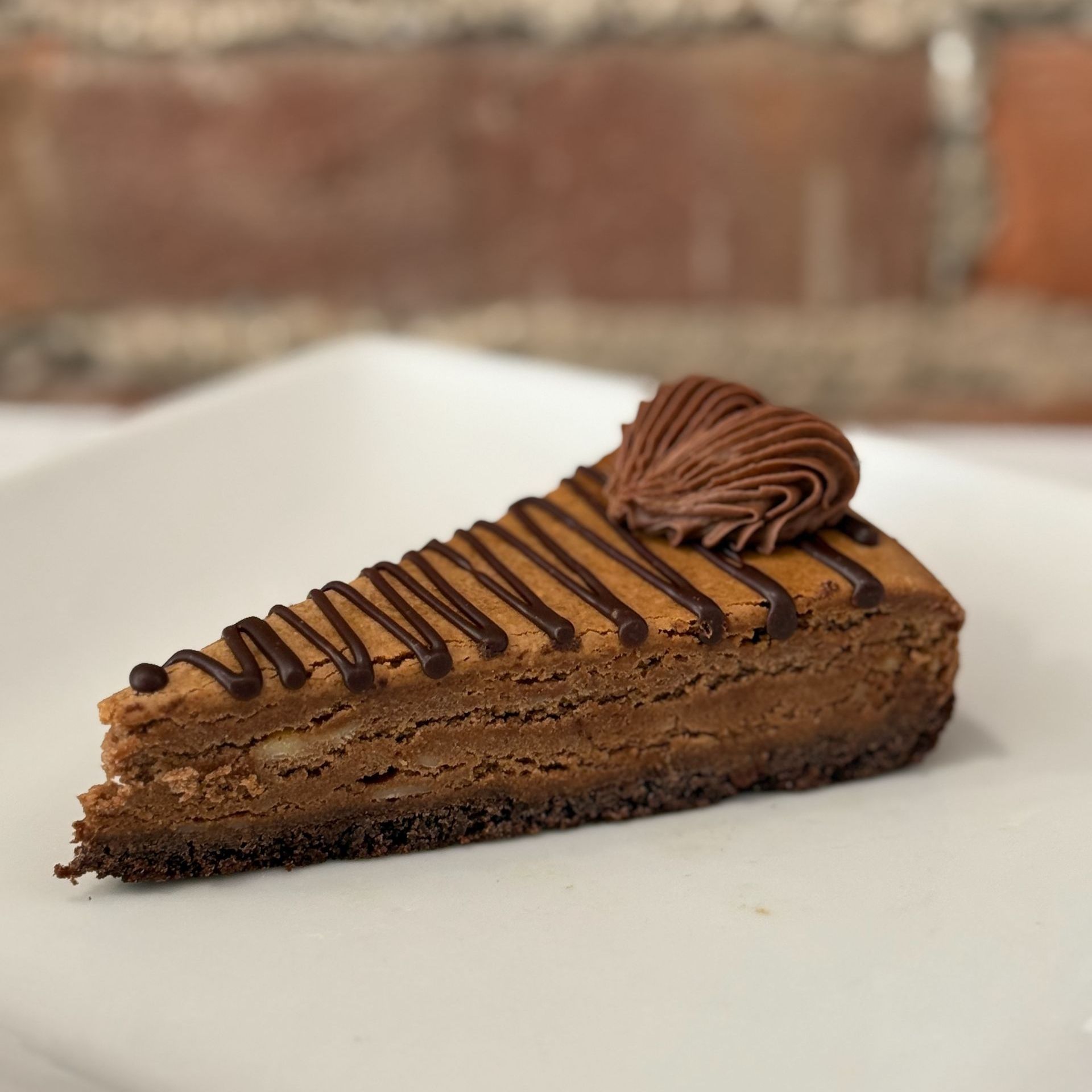 A slice of chocolate cheesecake on a white plate