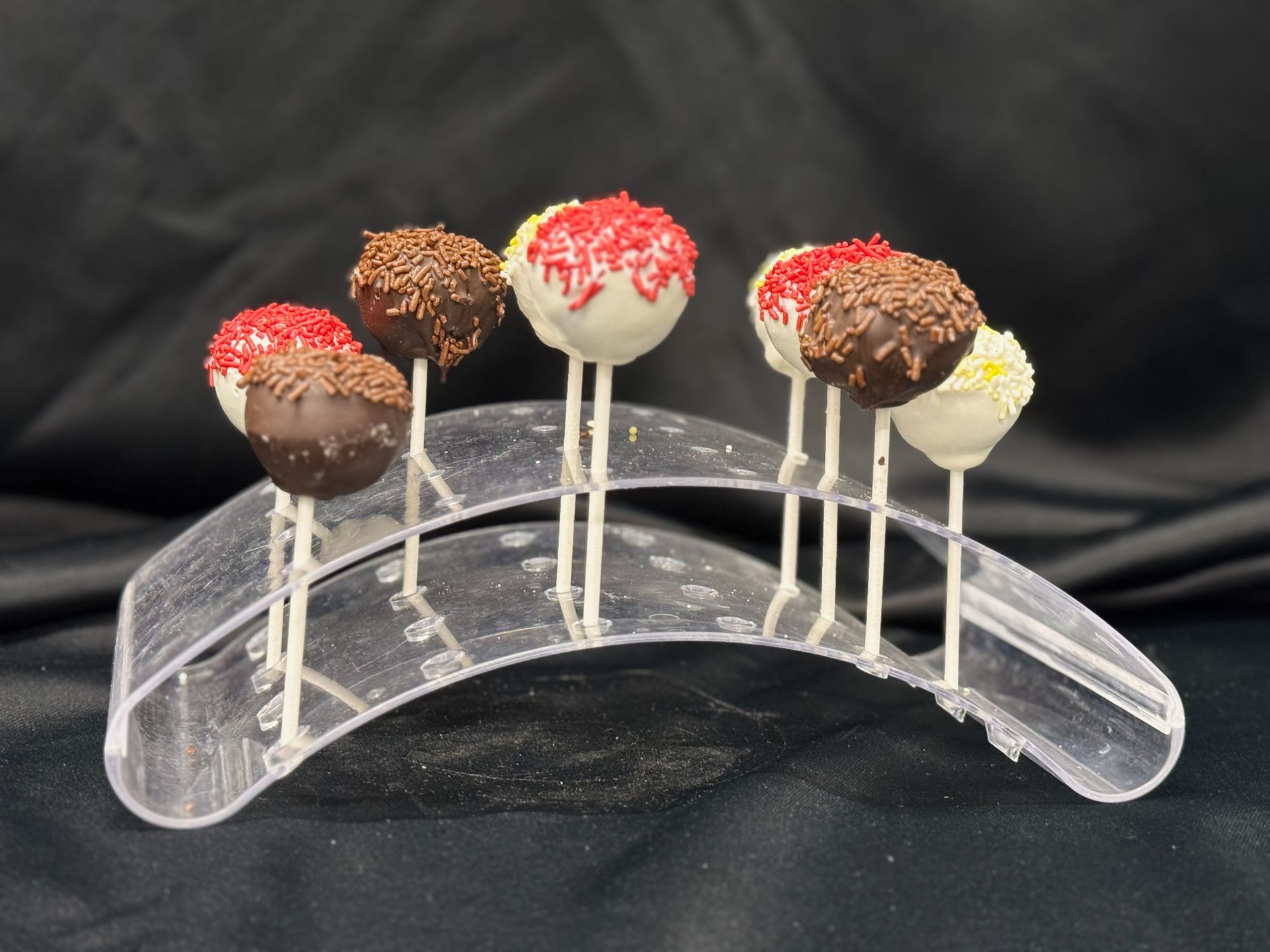 A display of cake pops in a clear holder