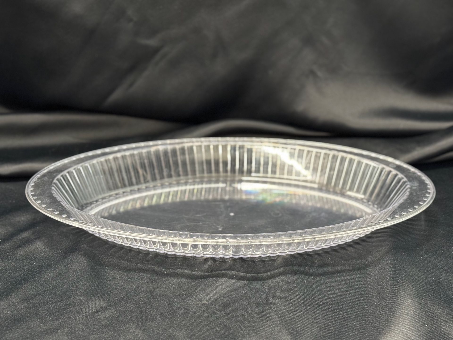 A clear plastic plate is sitting on a black cloth.