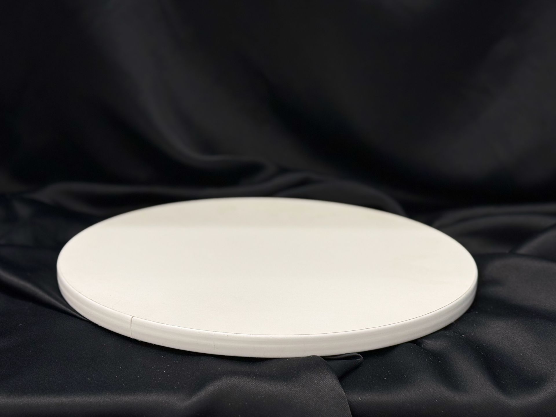 A white plate is sitting on a black cloth