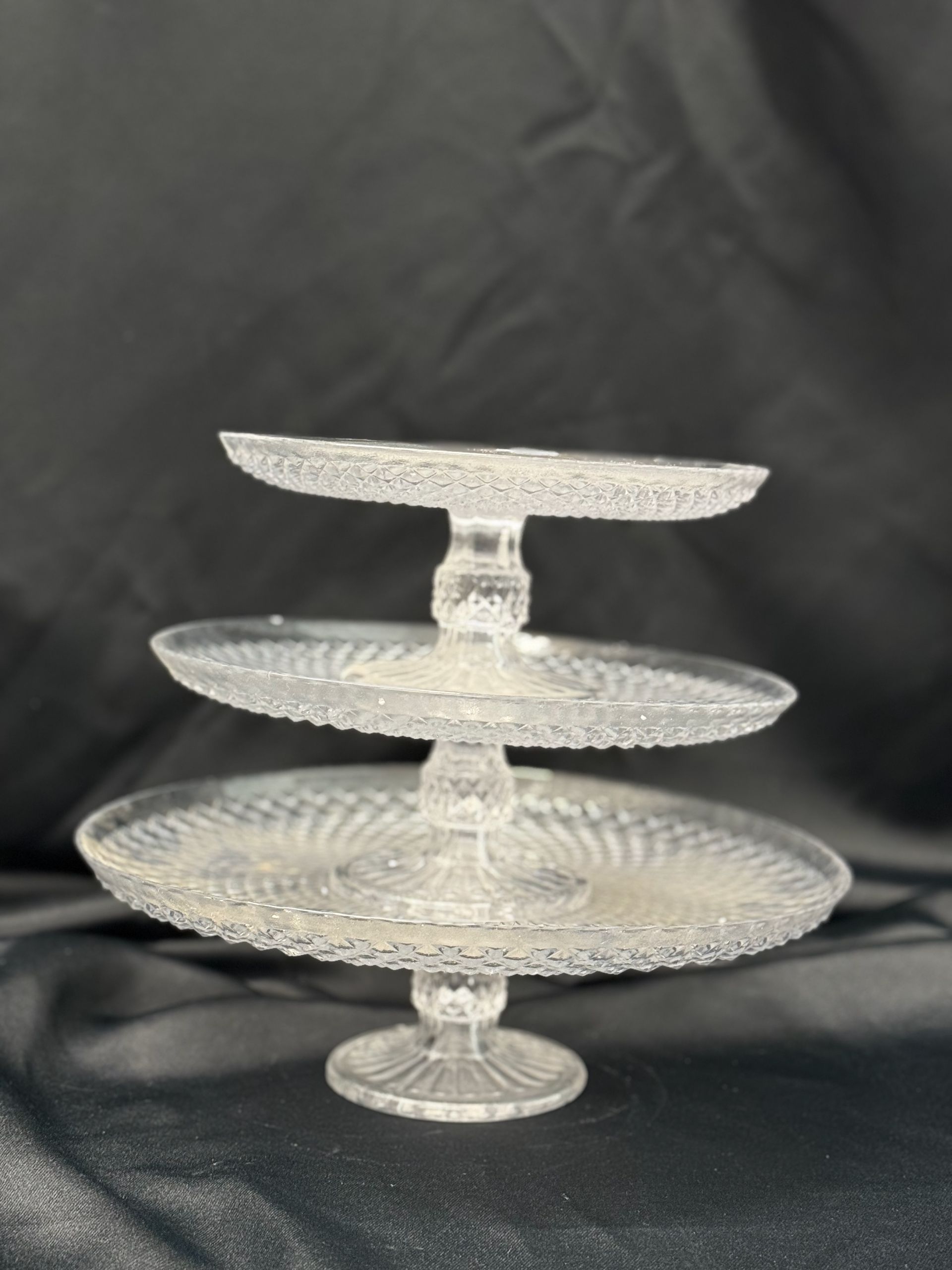 Three clear glass plates are stacked on top of each other on a table.