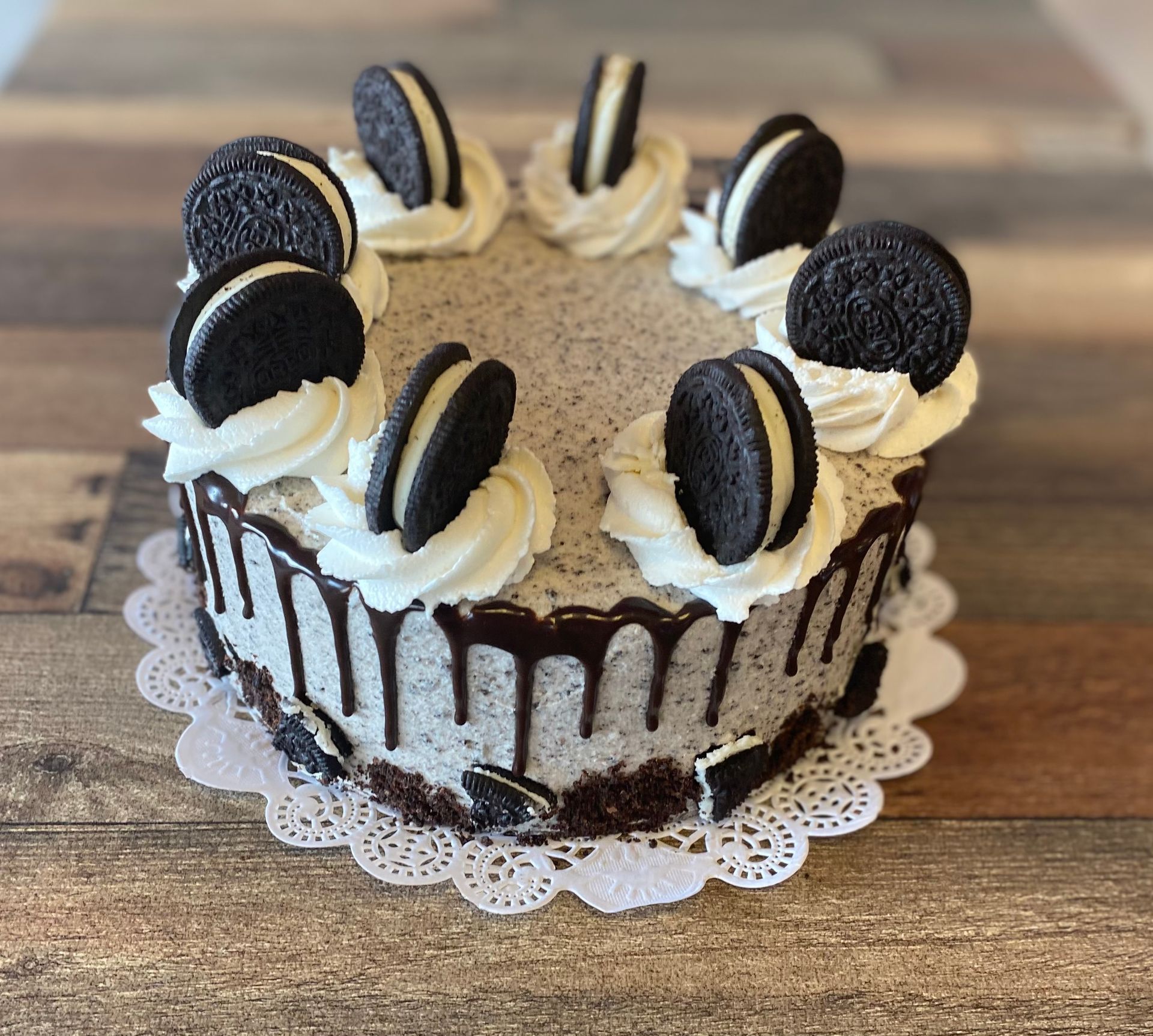 A cake with oreos on top of it on a wooden table.