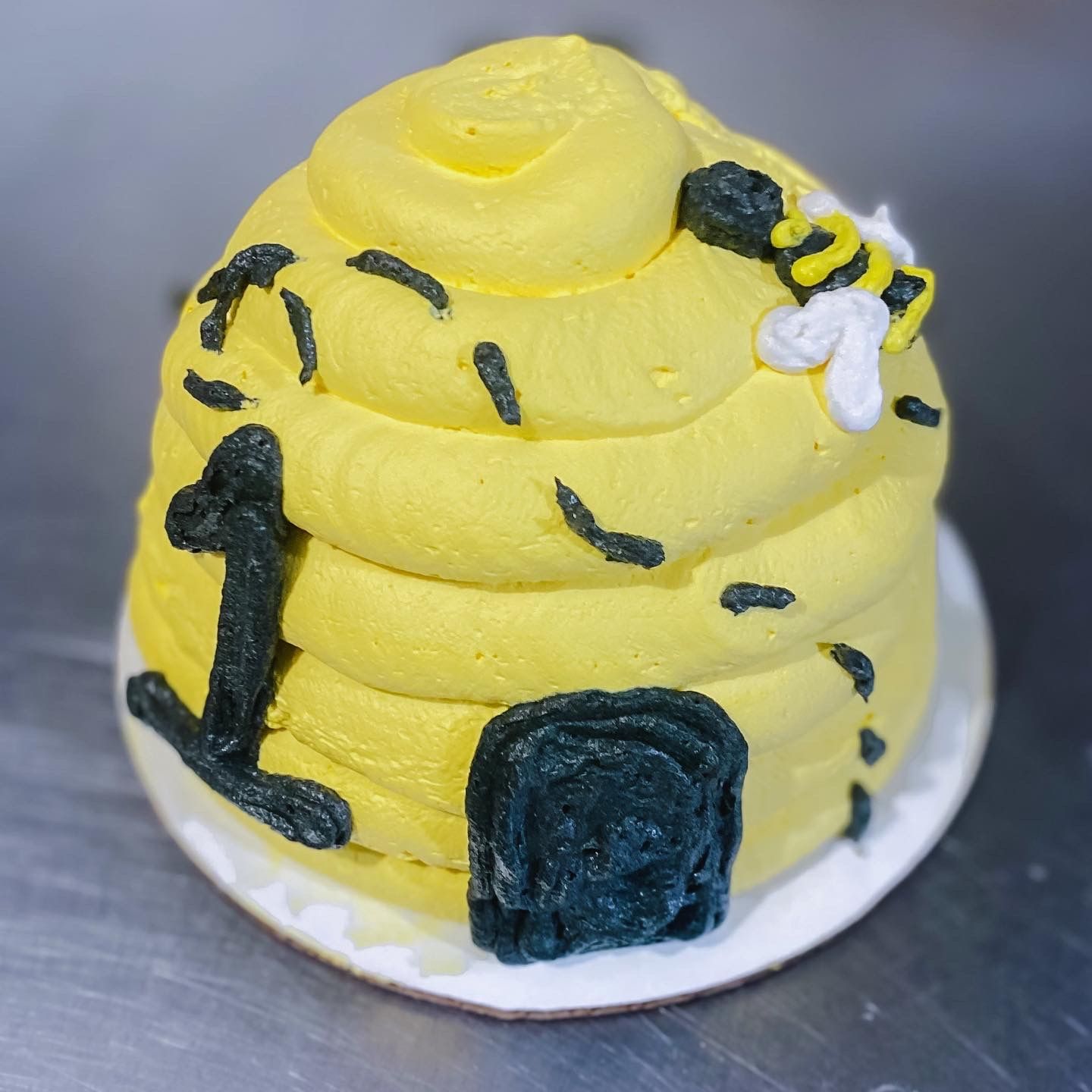 A beehive cake with a bee on top of it