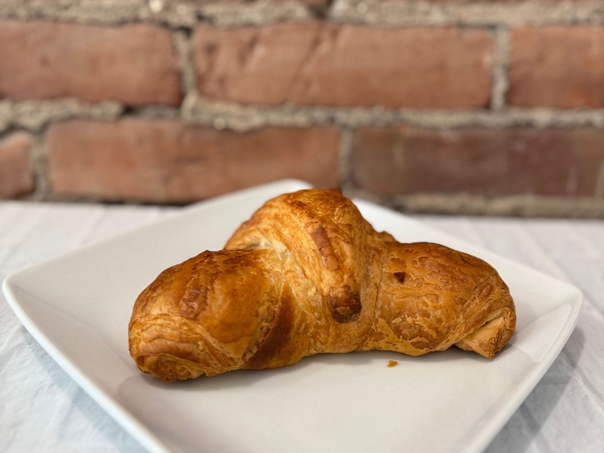 A close up of a croissant on a white plate