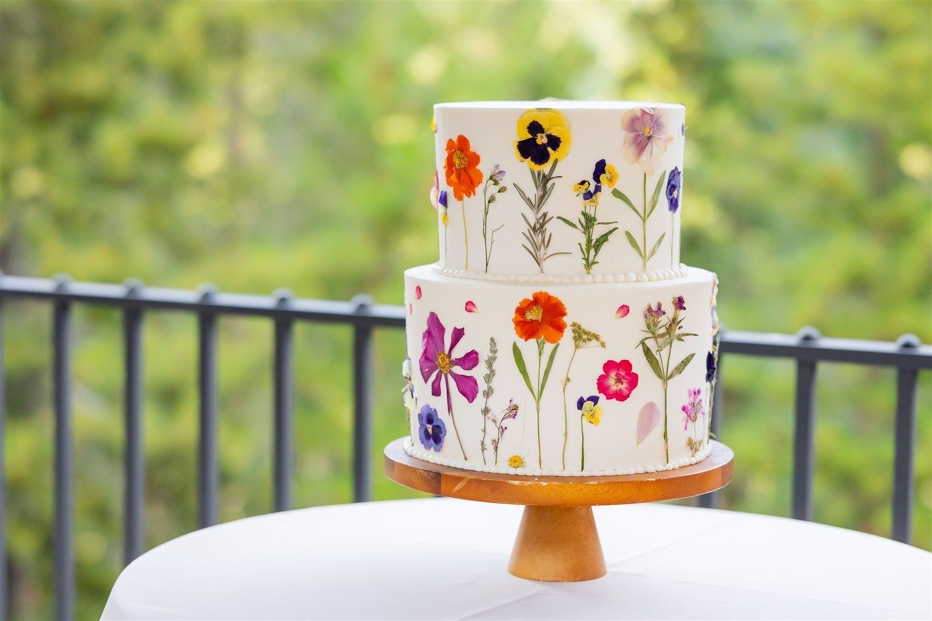 A white cake with flowers on it and the letter w on top
