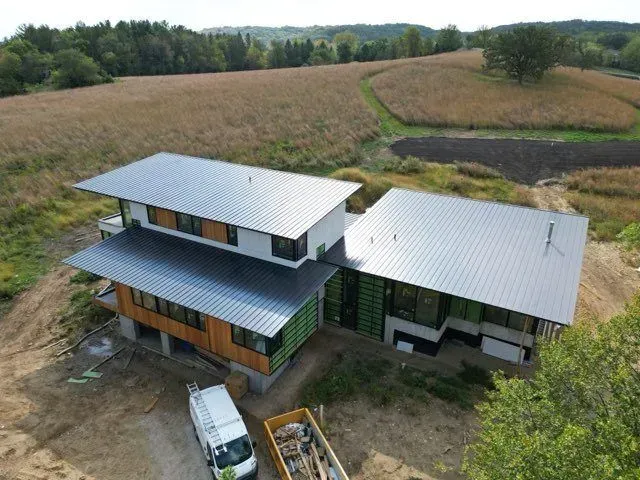 An aerial view of a house under construction in the middle of a field.