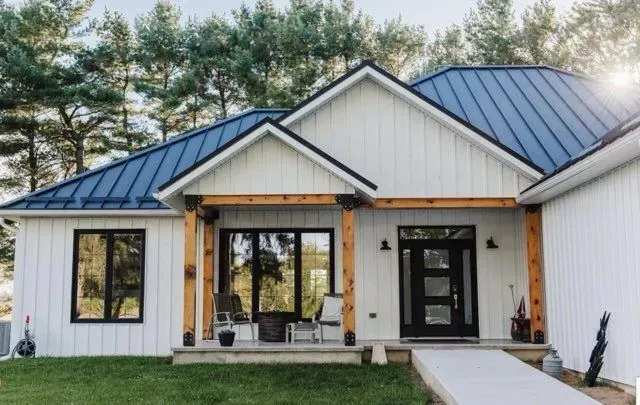 A white house with a blue roof and black windows.