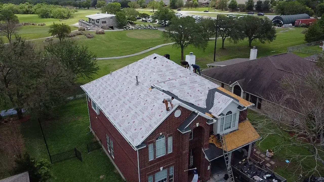 An aerial view of a house with a new roof being installed.