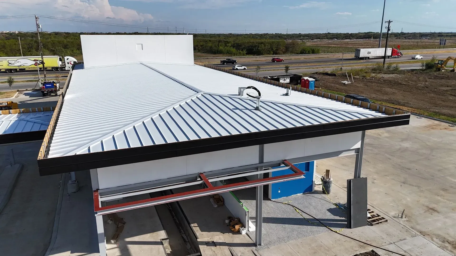 An aerial view of a building under construction with a white roof.