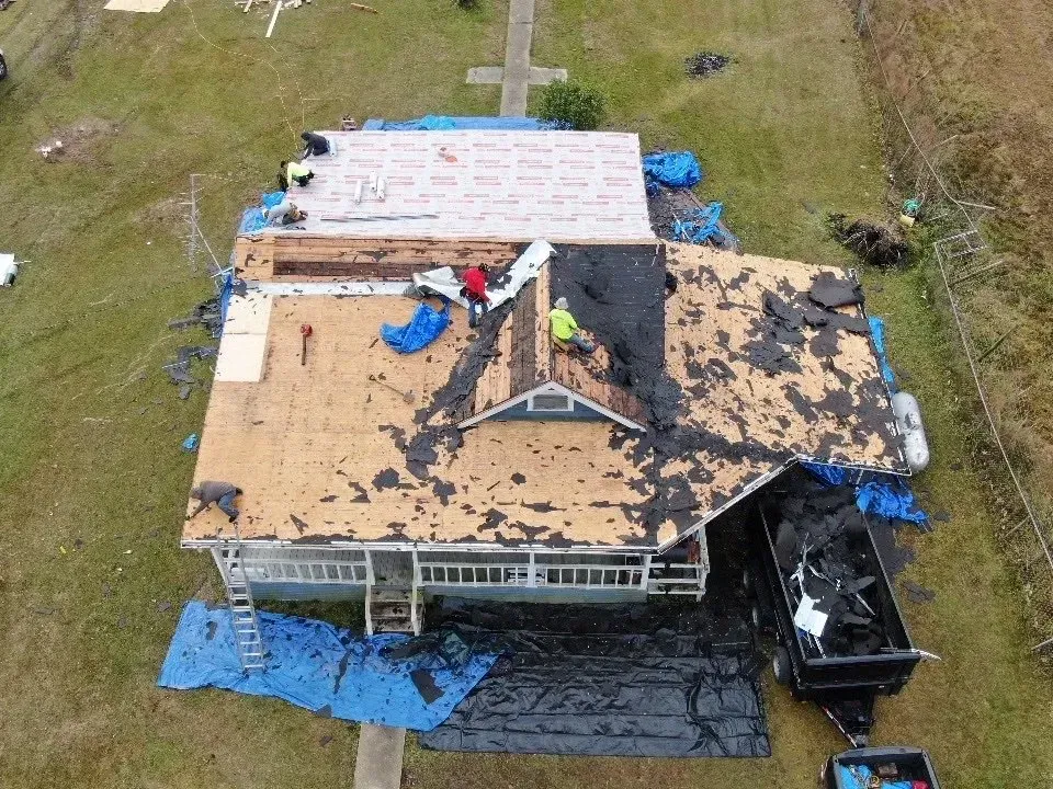 An aerial view of a house being remodeled with a roof being installed.