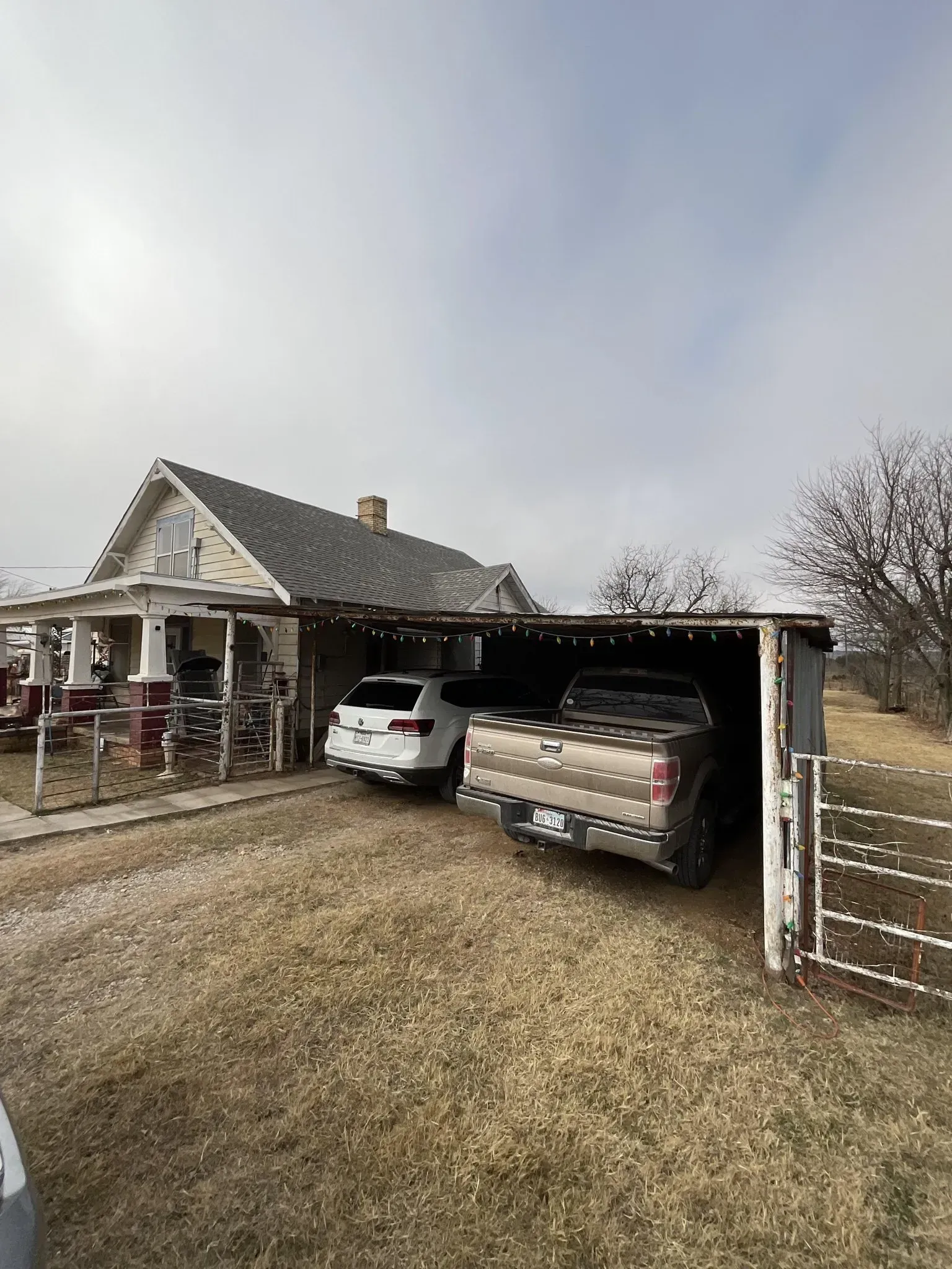 A couple of cars are parked in front of a house.